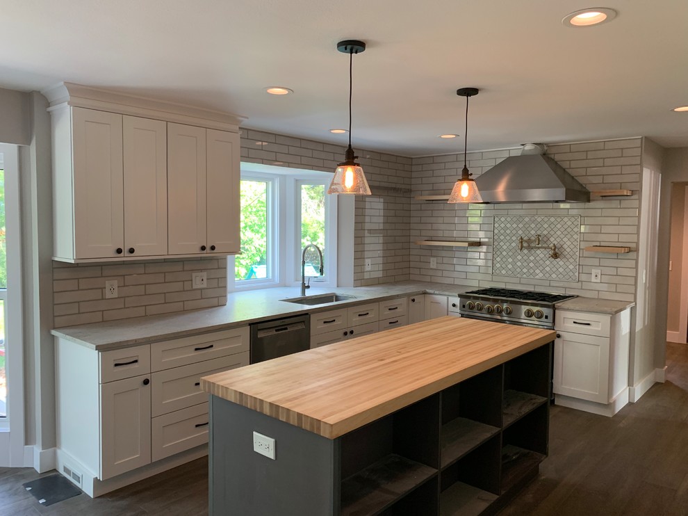 Design ideas for a mid-sized country u-shaped separate kitchen in Denver with an undermount sink, recessed-panel cabinets, grey cabinets, white splashback, ceramic splashback, stainless steel appliances, with island, brown floor, grey benchtop, granite benchtops and vinyl floors.