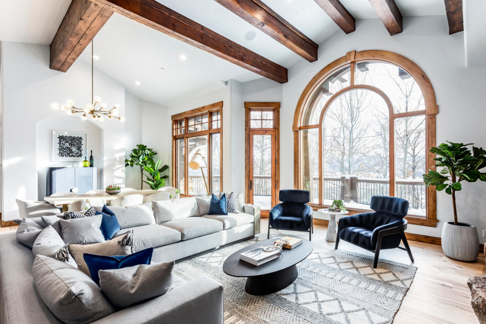 Large contemporary formal open concept living room in Salt Lake City with multi-coloured walls, a standard fireplace, a stone fireplace surround, a wall-mounted tv, beige floor, exposed beam and light hardwood floors.