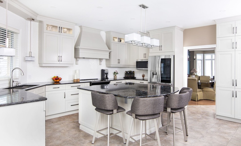 Large transitional u-shaped separate kitchen with a double-bowl sink, recessed-panel cabinets, grey cabinets, granite benchtops, stainless steel appliances, ceramic floors, with island, beige floor and black benchtop.