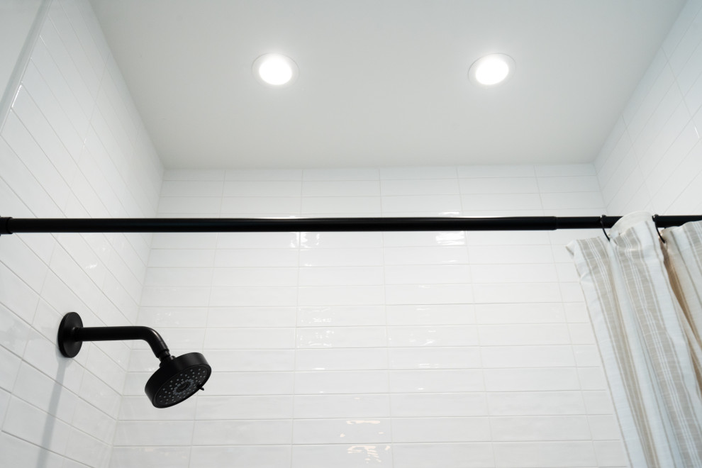 Exempel på ett litet klassiskt vit vitt badrum, med släta luckor, skåp i ljust trä, ett badkar i en alkov, en dusch/badkar-kombination, svart och vit kakel, porslinskakel, vita väggar, klinkergolv i keramik, ett undermonterad handfat, bänkskiva i kvarts, beiget golv och dusch med duschdraperi