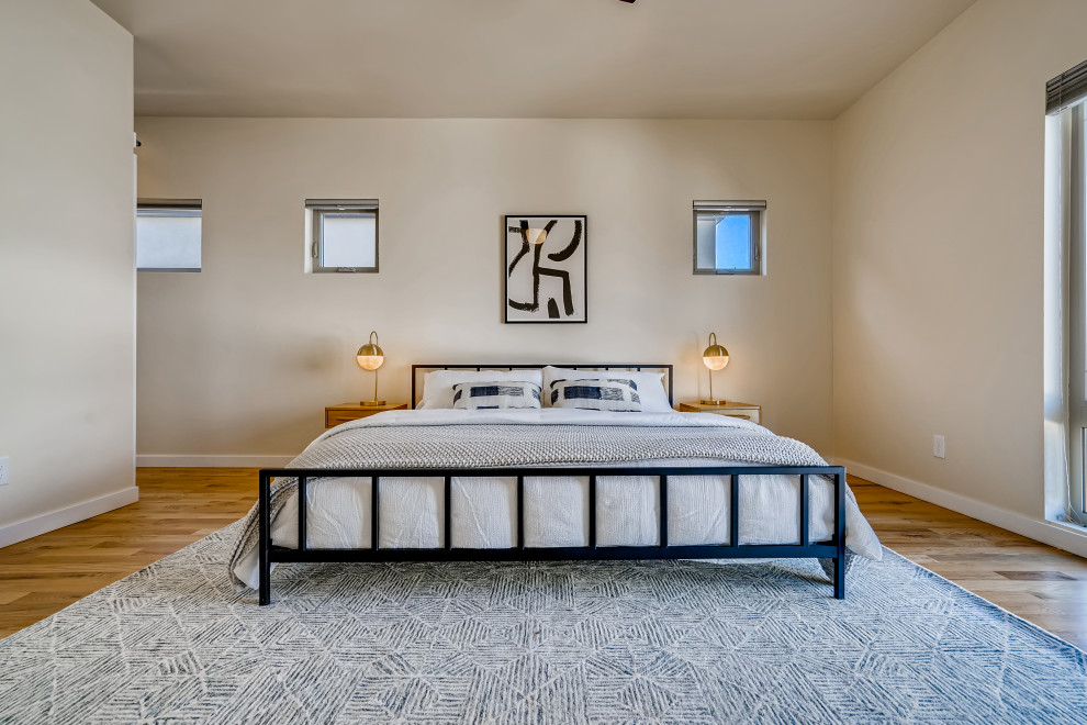 Contemporary master bedroom in Denver with light hardwood floors.