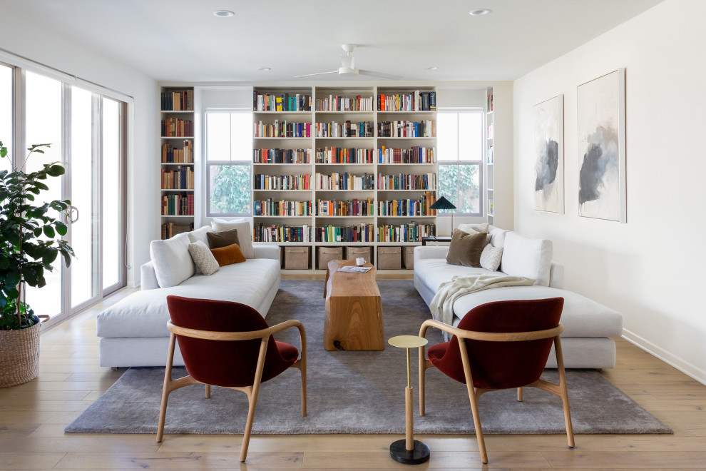 Idee per un grande soggiorno stile marino aperto con libreria, pareti bianche, parquet chiaro e nessuna TV