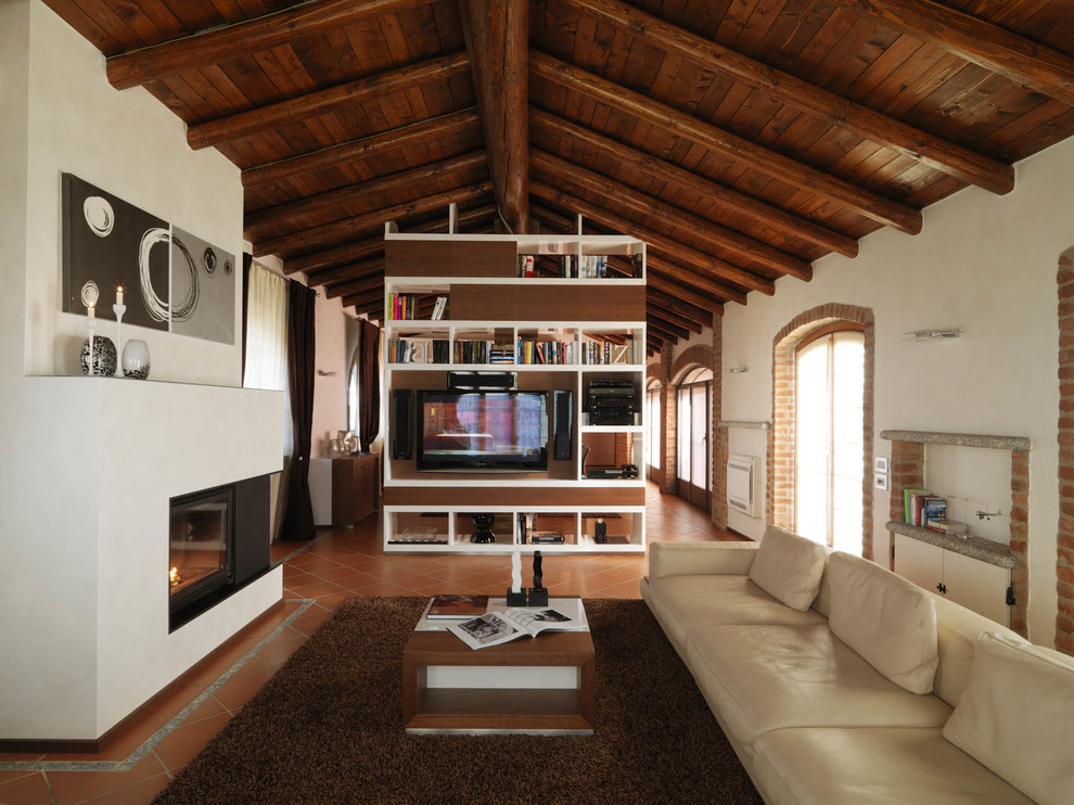 Photo of a country open concept living room in Milan with white walls, terra-cotta floors, a ribbon fireplace and a plaster fireplace surround.