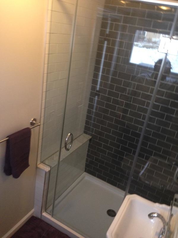 Small contemporary 3/4 bathroom in Philadelphia with a pedestal sink, glass-front cabinets, an alcove shower, a two-piece toilet, black tile, ceramic tile, grey walls and ceramic floors.