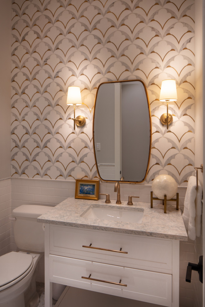 This is an example of a mid-sized country powder room in Dallas with recessed-panel cabinets, white cabinets, a two-piece toilet, black and white tile, stone tile, grey walls, porcelain floors, an undermount sink, marble benchtops, white floor and grey benchtops.