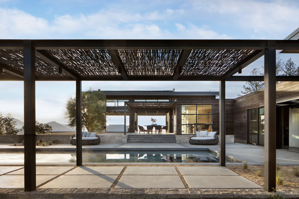 Ispirazione per un'ampia piscina a sfioro infinito design rettangolare dietro casa