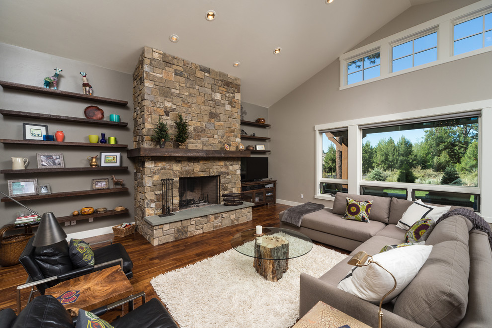 Photo of a large contemporary open concept living room in Other with grey walls, a standard fireplace and a stone fireplace surround.