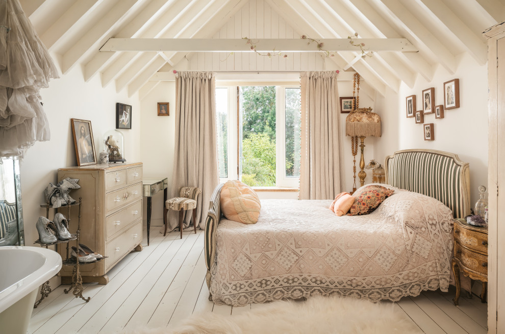 Mittelgroßes Shabby-Style Hauptschlafzimmer mit weißer Wandfarbe, gebeiztem Holzboden und weißem Boden in Sussex