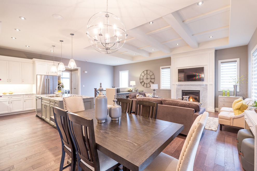 Inspiration for a large transitional open plan dining in Toronto with grey walls, dark hardwood floors, a standard fireplace, a wood fireplace surround and brown floor.