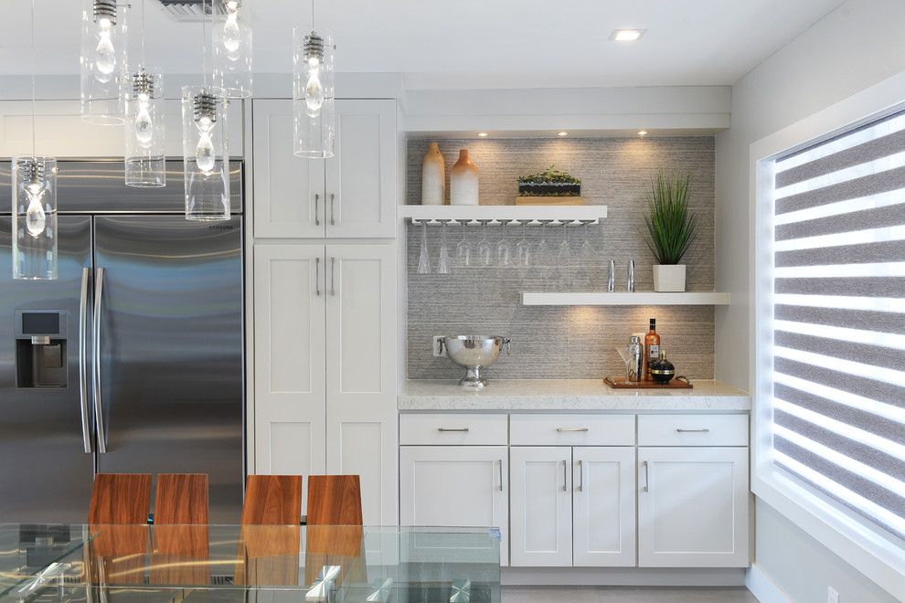 Inspiration for a large transitional single-wall open concept kitchen remodel in Miami with shaker cabinets, white cabinets, quartz countertops, gray backsplash, porcelain backsplash, stainless steel appliances and an island