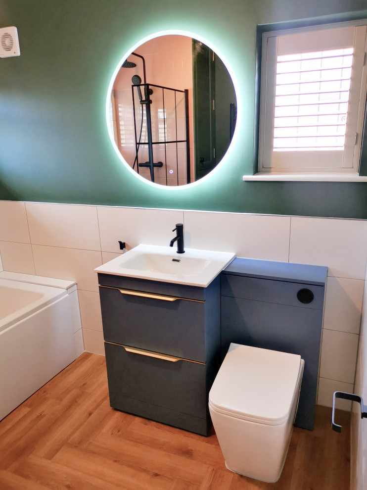 Inspiration pour une salle de bain traditionnelle de taille moyenne pour enfant avec un placard à porte plane, des portes de placard bleues, une baignoire posée, un combiné douche/baignoire, WC à poser, un carrelage rose, des carreaux de céramique, un mur vert, un sol en vinyl, un plan de toilette en quartz modifié, un plan de toilette blanc, meuble simple vasque et meuble-lavabo sur pied.