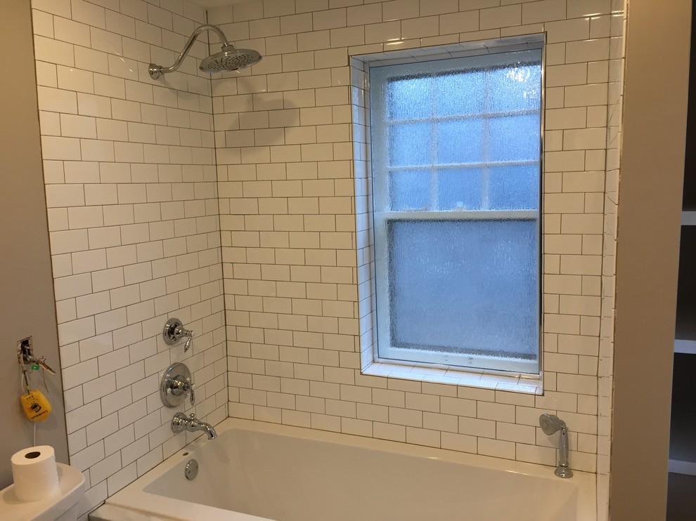 Photo of a mid-sized contemporary master bathroom in Kansas City with a drop-in tub, shaker cabinets, dark wood cabinets, a shower/bathtub combo, white tile, subway tile, grey walls, porcelain floors, an undermount sink, quartzite benchtops, grey floor, a shower curtain and white benchtops.