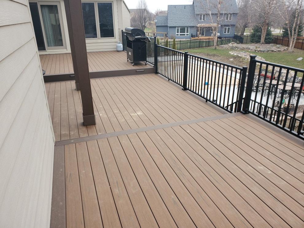 Large backyard second story metal railing deck photo with no cover