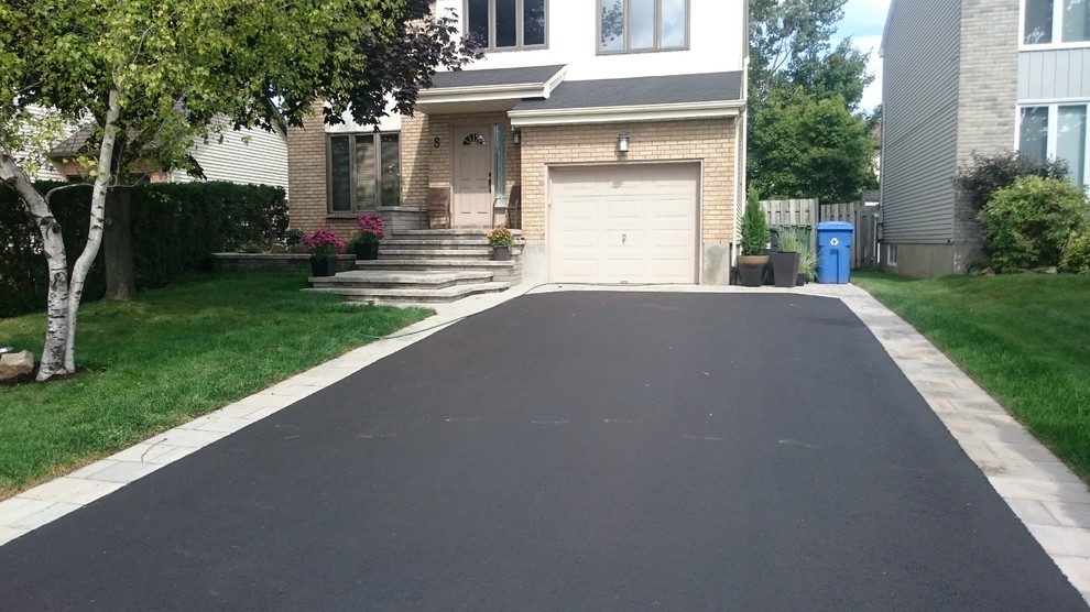Design ideas for a contemporary front yard driveway in Montreal with concrete pavers.