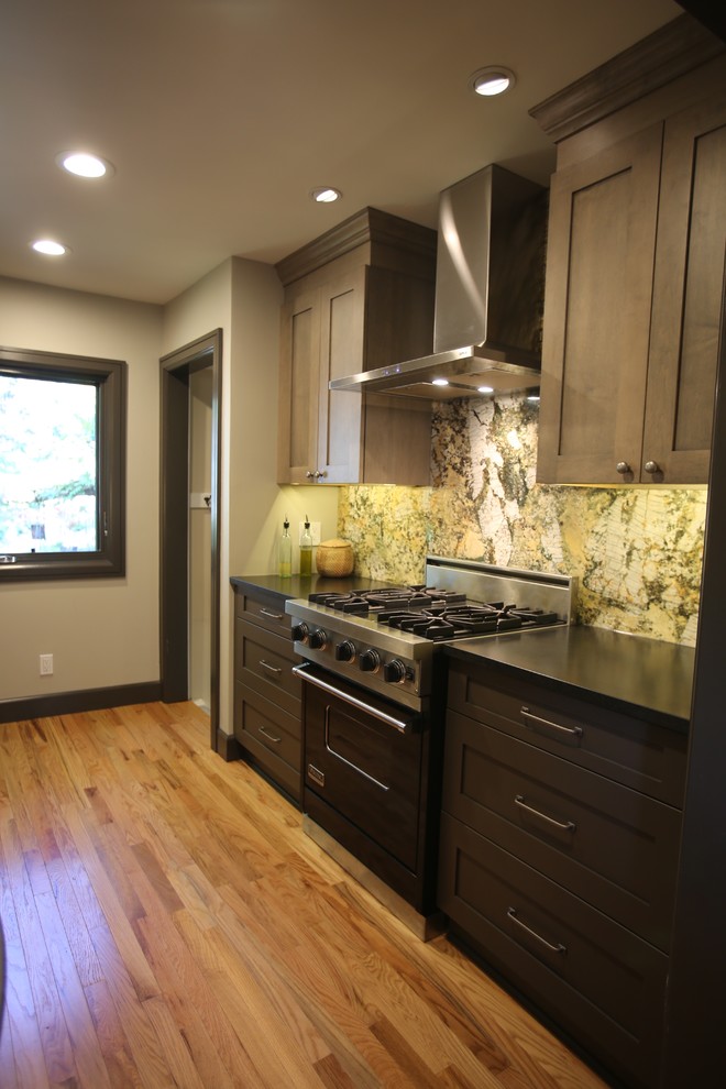 Small transitional galley separate kitchen in Detroit with an undermount sink, shaker cabinets, grey cabinets, granite benchtops, green splashback, stone slab splashback, stainless steel appliances, medium hardwood floors and no island.