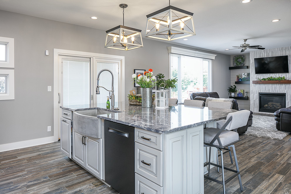 Inspiration for a mid-sized transitional single-wall cement tile floor and multicolored floor eat-in kitchen remodel with a farmhouse sink, raised-panel cabinets, distressed cabinets, granite countertops, white backsplash, subway tile backsplash, black appliances, an island and gray countertops