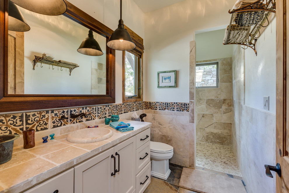 Mid-sized traditional 3/4 bathroom in Austin with recessed-panel cabinets, beige cabinets, an alcove tub, a shower/bathtub combo, a two-piece toilet, beige tile, travertine, beige walls, slate floors, a drop-in sink, terrazzo benchtops, multi-coloured floor and a shower curtain.