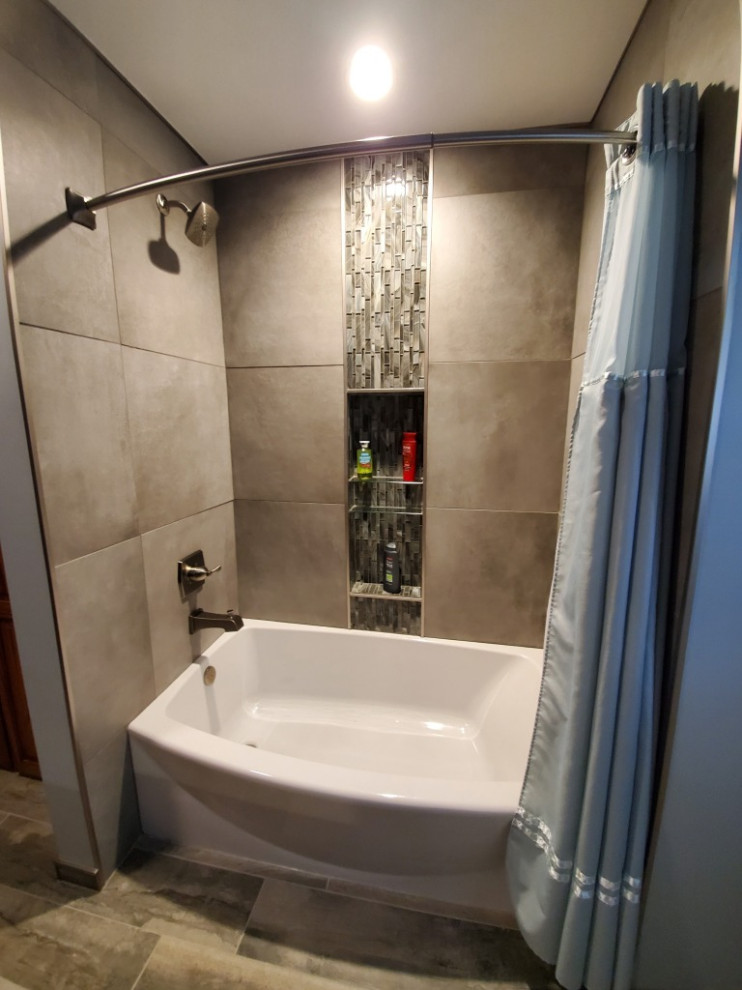 Mid-sized transitional master gray tile and porcelain tile porcelain tile, brown floor and double-sink alcove bathtub photo with recessed-panel cabinets, dark wood cabinets, blue walls, an undermount sink, quartz countertops, blue countertops and a niche