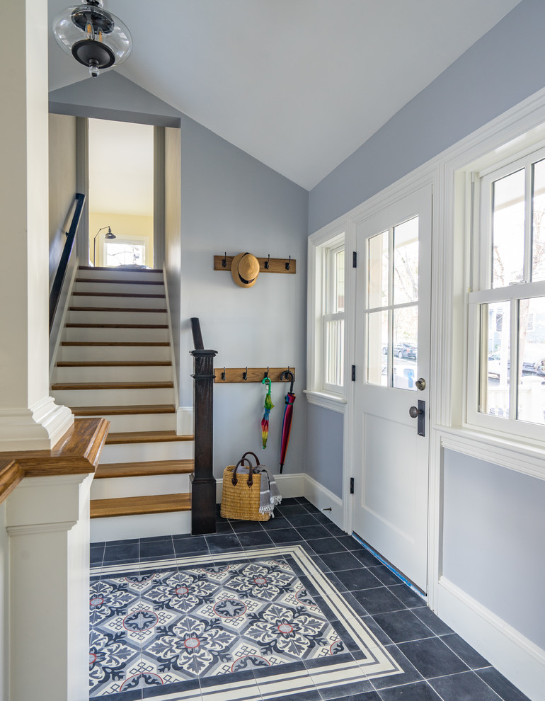 This is an example of a large transitional hallway in Boston with grey walls, concrete floors and black floor.