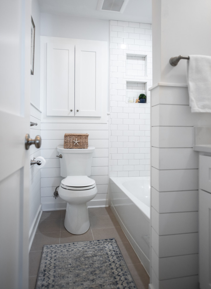 Inspiration för ett litet maritimt vit vitt en-suite badrum, med skåp i shakerstil, vita skåp, ett badkar i en alkov, en dusch/badkar-kombination, en toalettstol med separat cisternkåpa, grå kakel, stenkakel, klinkergolv i keramik, ett undermonterad handfat, bänkskiva i kvarts och dusch med duschdraperi