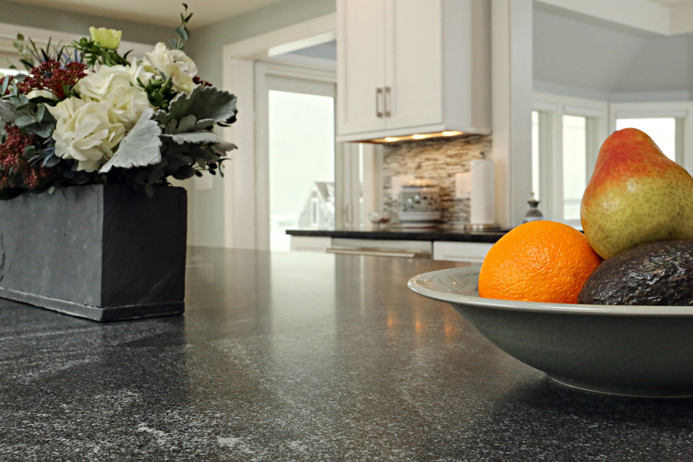 Inspiration for a mid-sized transitional l-shaped light wood floor open concept kitchen remodel in Boston with an undermount sink, shaker cabinets, white cabinets, granite countertops, gray backsplash, matchstick tile backsplash, stainless steel appliances and an island