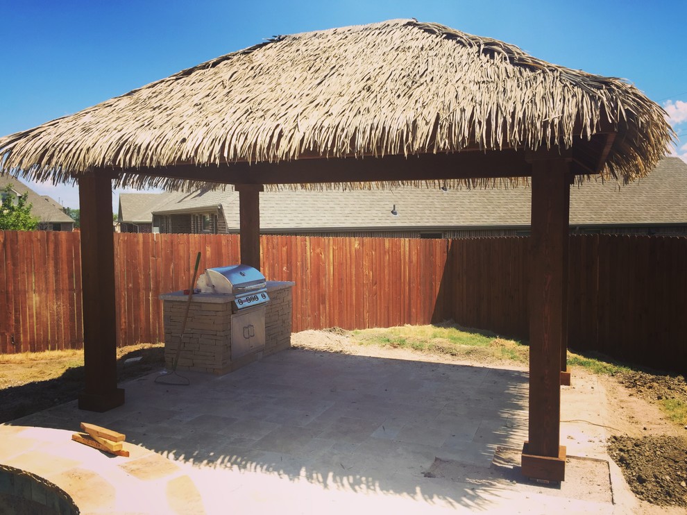 Large tropical backyard patio in Dallas with an outdoor kitchen, concrete slab and a gazebo/cabana.