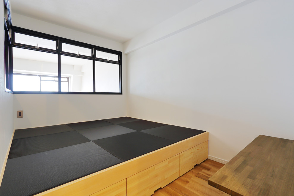 This is an example of a small modern master bedroom in Tokyo with white walls and medium hardwood floors.