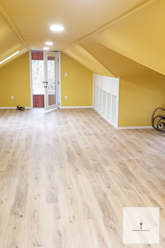 This is an example of a large contemporary formal enclosed living room in Seattle with yellow walls, laminate floors, brown floors and a vaulted ceiling.
