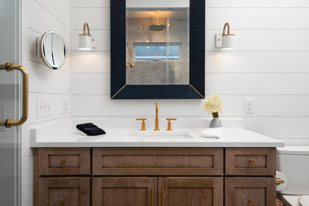 Cette photo montre une salle de bain bord de mer en bois brun avec un mur blanc, une cabine de douche à porte battante, meuble simple vasque, meuble-lavabo encastré et du lambris de bois.
