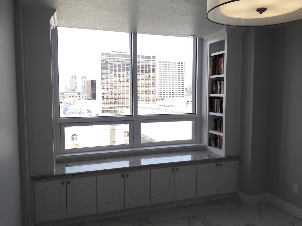 Large home office in Houston with a library, grey walls, porcelain floors and white floor.
