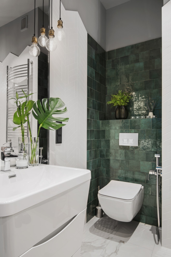 Exemple d'un petit WC suspendu industriel avec un placard à porte plane, des portes de placard blanches, un carrelage vert, des carreaux de céramique, un mur vert, un sol en carrelage de porcelaine, un lavabo posé, un sol blanc et meuble-lavabo sur pied.