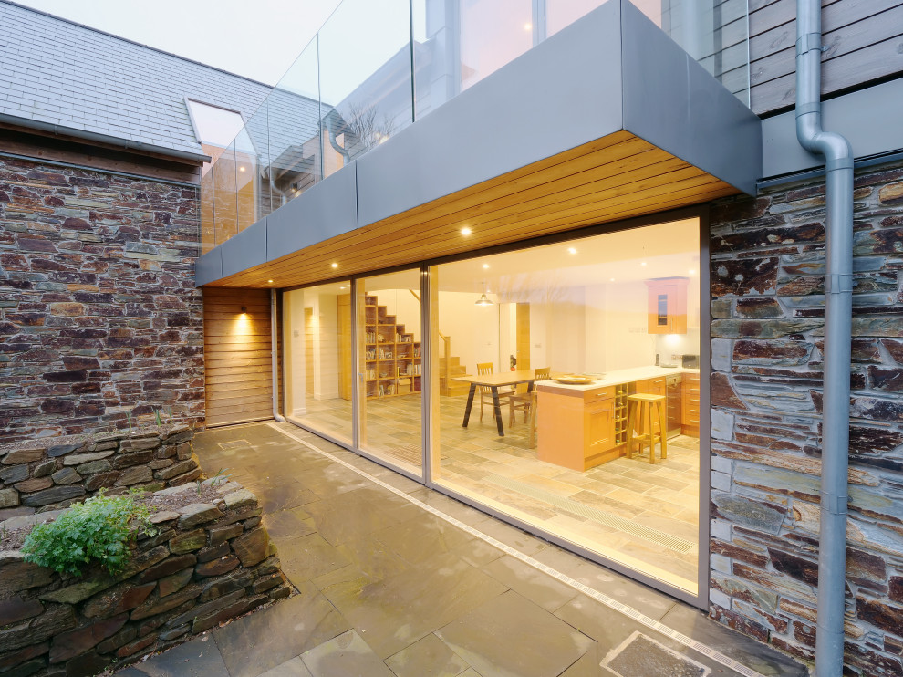 This is an example of a mid-sized contemporary balcony in Cornwall with glass railing.