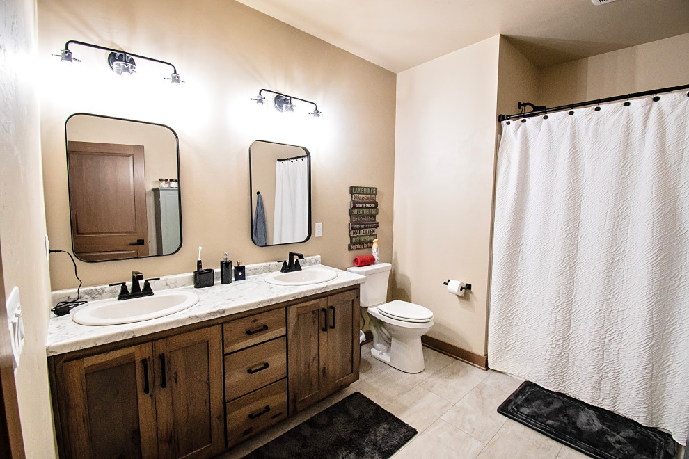 Example of a mid-sized mountain style kids' ceramic tile, multicolored floor and double-sink alcove bathtub design with flat-panel cabinets, medium tone wood cabinets, a two-piece toilet, beige walls, a drop-in sink, laminate countertops, multicolored countertops and a freestanding vanity