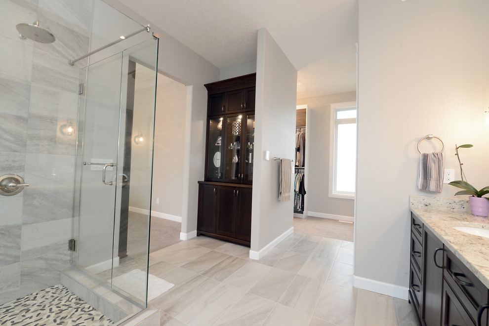 Photo of a mid-sized contemporary master bathroom in Edmonton with beaded inset cabinets, dark wood cabinets, a freestanding tub, a corner shower, black and white tile, stone slab, porcelain floors, an undermount sink and granite benchtops.