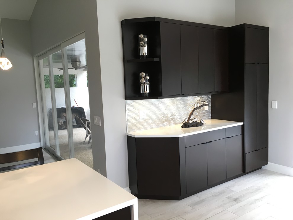 Example of a mid-sized transitional galley porcelain tile eat-in kitchen design in Miami with dark wood cabinets, quartz countertops, metal backsplash, stainless steel appliances, an island and a single-bowl sink