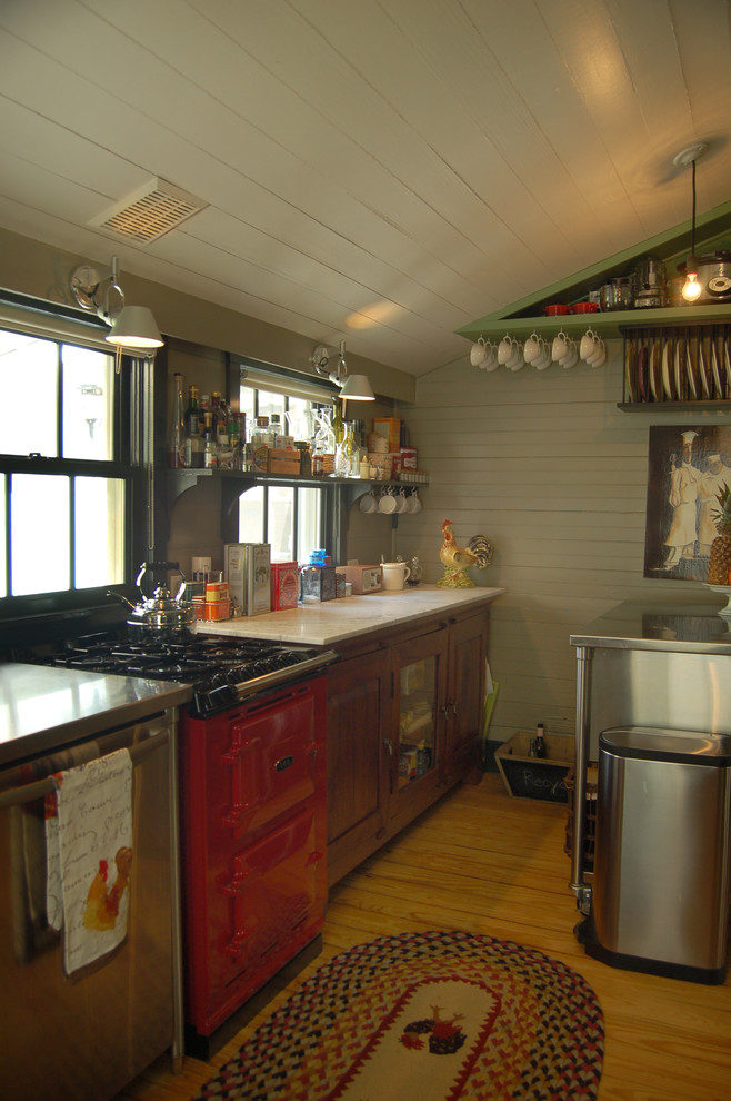 This is an example of a country separate kitchen in Austin with coloured appliances and marble benchtops.
