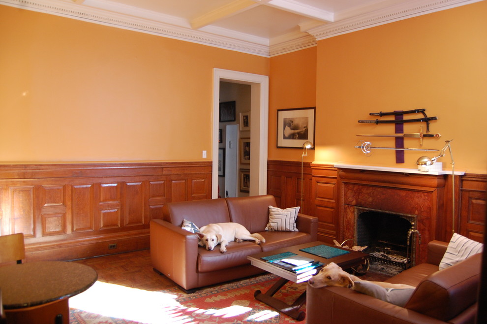 Design ideas for a large contemporary formal enclosed living room in New York with orange walls, light hardwood floors, a standard fireplace and a wood fireplace surround.