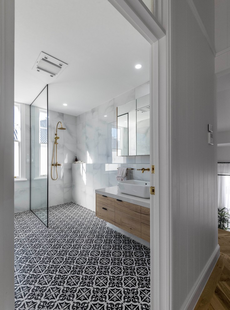 This is an example of a beach style kids bathroom in Brisbane with light wood cabinets, an open shower, white tile, ceramic tile, ceramic floors, black floor, an open shower and white benchtops.