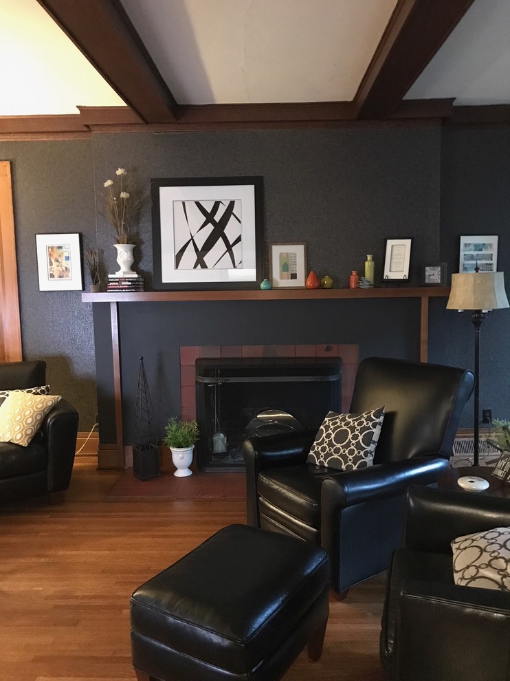 Photo of a mid-sized transitional formal open concept living room in Omaha with black walls, medium hardwood floors, a standard fireplace, a tile fireplace surround, no tv and brown floor.