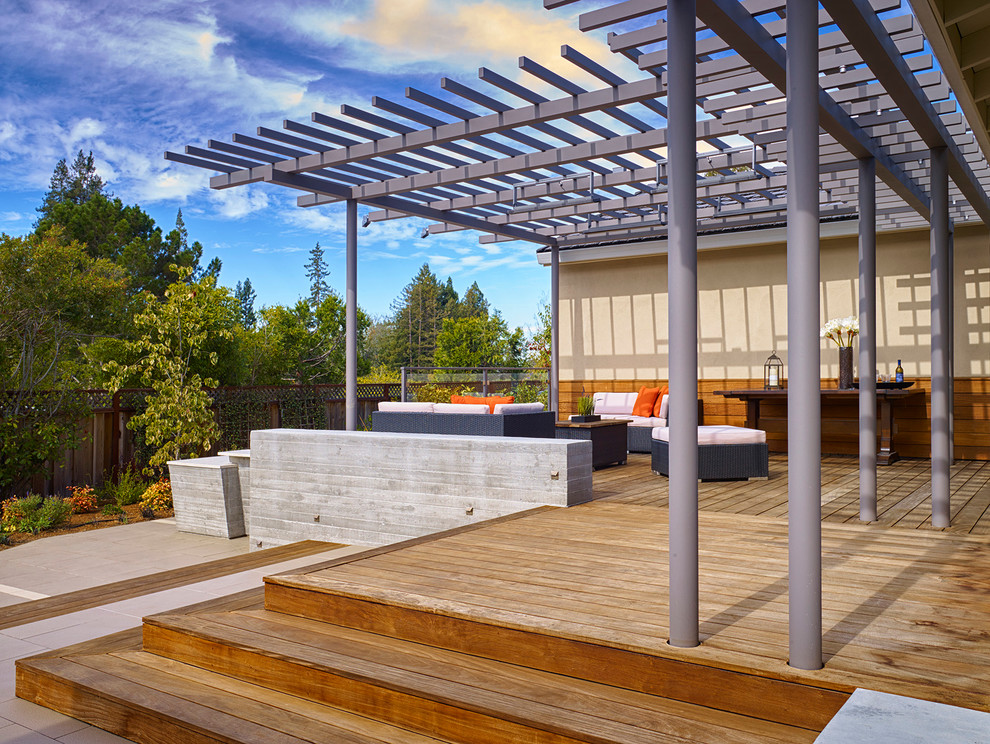 This is an example of a large contemporary backyard patio in San Francisco with a fire feature, concrete pavers and a pergola.