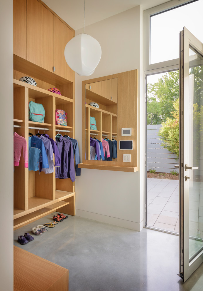 This is an example of a mid-sized modern gender-neutral dressing room in San Francisco with open cabinets, brown cabinets, linoleum floors and grey floor.