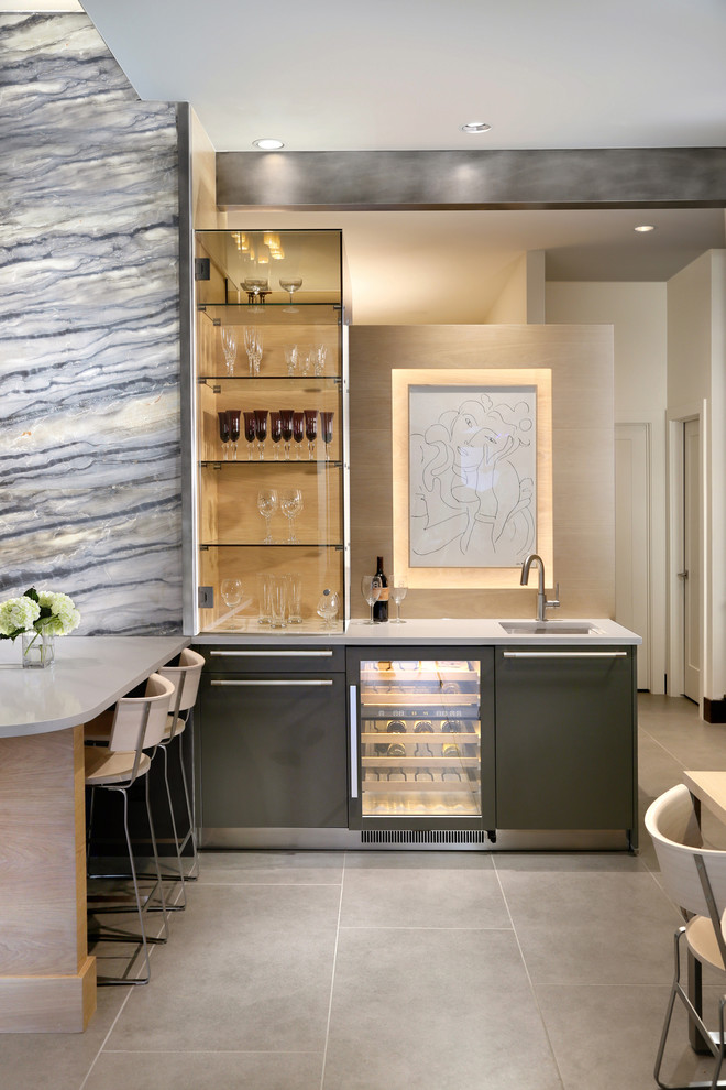 Photo of a mid-sized contemporary l-shaped seated home bar in Orange County with an undermount sink, flat-panel cabinets, black cabinets, marble benchtops, stone slab splashback, slate floors and beige splashback.