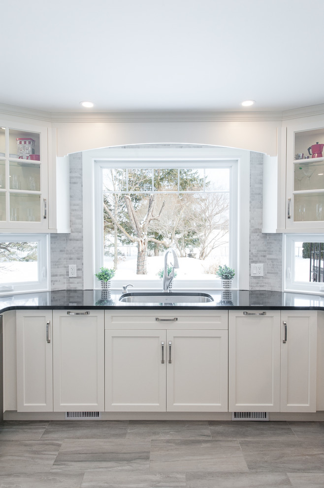 Open concept kitchen - large transitional u-shaped porcelain tile open concept kitchen idea in Ottawa with an undermount sink, shaker cabinets, white cabinets, quartz countertops, gray backsplash, porcelain backsplash, stainless steel appliances and a peninsula