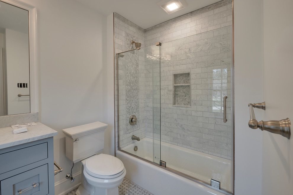 This is an example of a small transitional kids bathroom in Philadelphia with flat-panel cabinets, grey cabinets, a drop-in tub, a corner shower, a one-piece toilet, multi-coloured tile, marble, white walls, marble floors, marble benchtops, multi-coloured floor and a sliding shower screen.