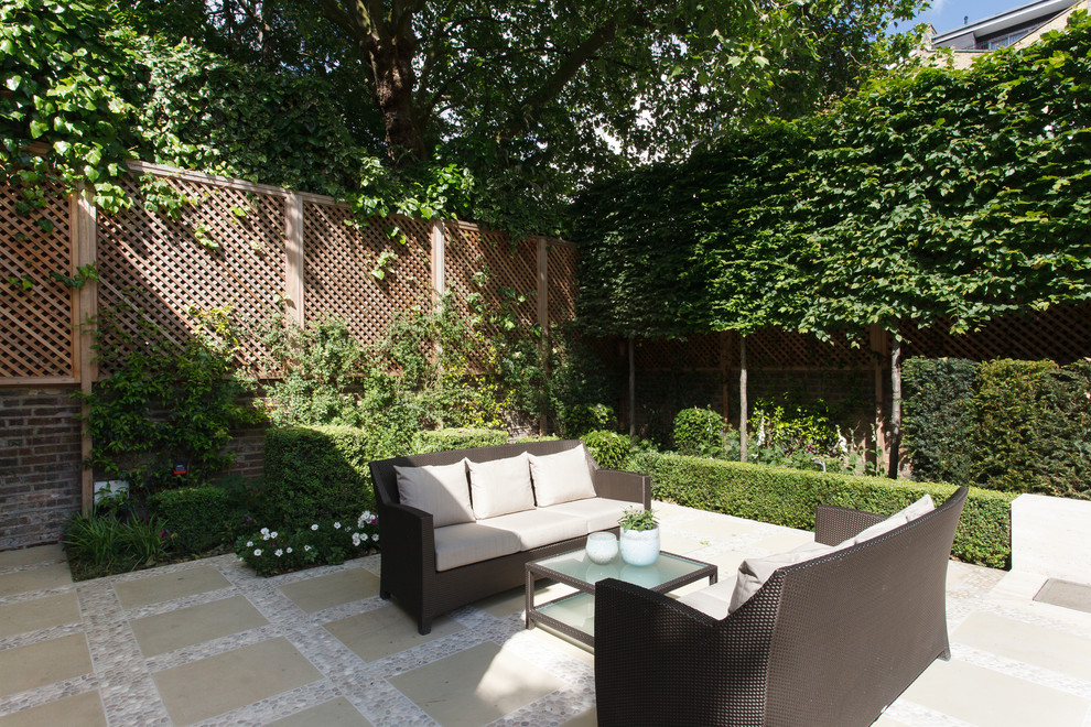 Design ideas for a small contemporary courtyard patio in London with a water feature and natural stone pavers.