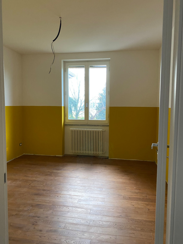 Idée de décoration pour une chambre d'enfant de 1 à 3 ans nordique de taille moyenne avec un mur jaune, parquet clair et un sol marron.