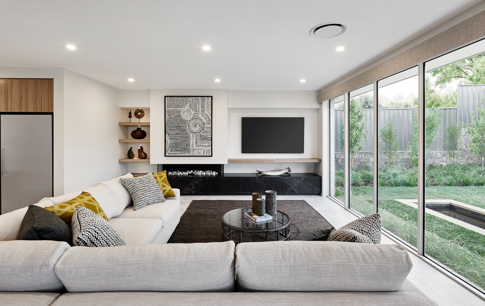 Photo of a contemporary open concept living room in Sydney with white walls, a ribbon fireplace, a plaster fireplace surround, a wall-mounted tv and white floor.