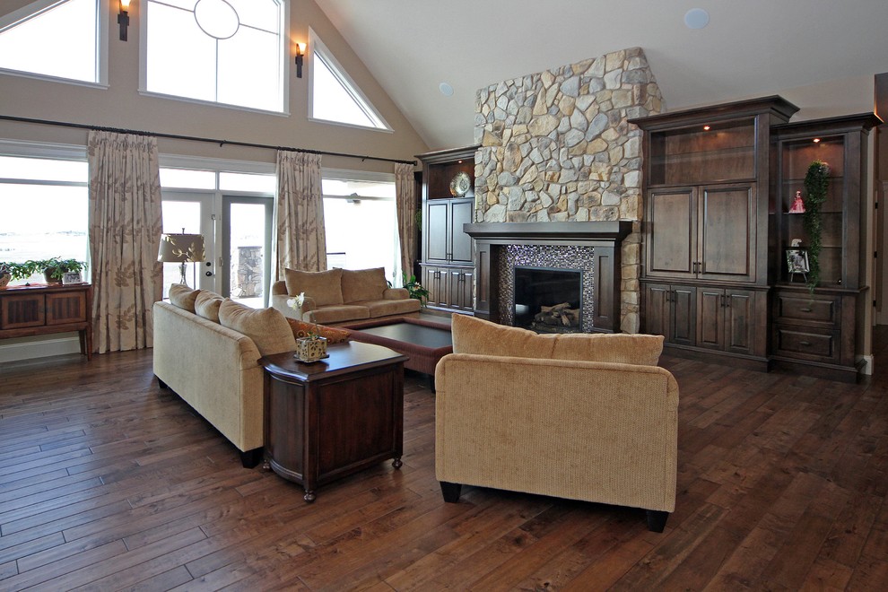 Inspiration for a traditional open concept living room in Calgary with brown walls, medium hardwood floors, a standard fireplace, a tile fireplace surround and a built-in media wall.