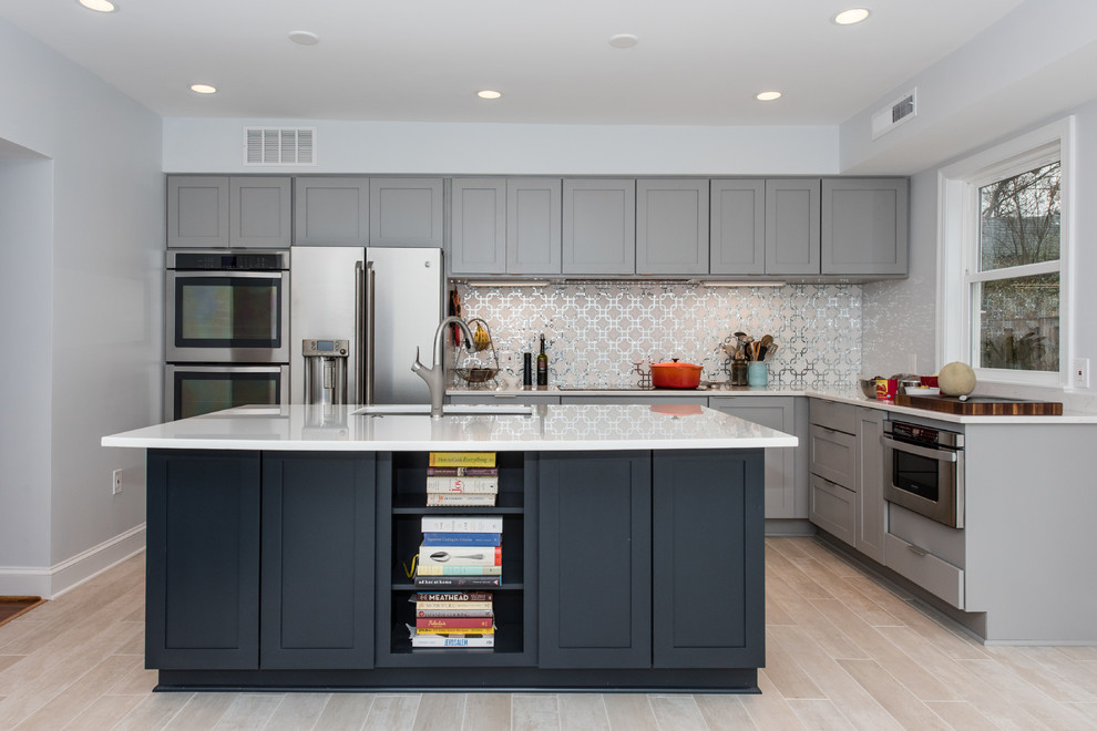 Mid-sized transitional l-shaped eat-in kitchen in DC Metro with an undermount sink, shaker cabinets, blue cabinets, glass benchtops, grey splashback, mosaic tile splashback, stainless steel appliances, porcelain floors, with island and beige floor.