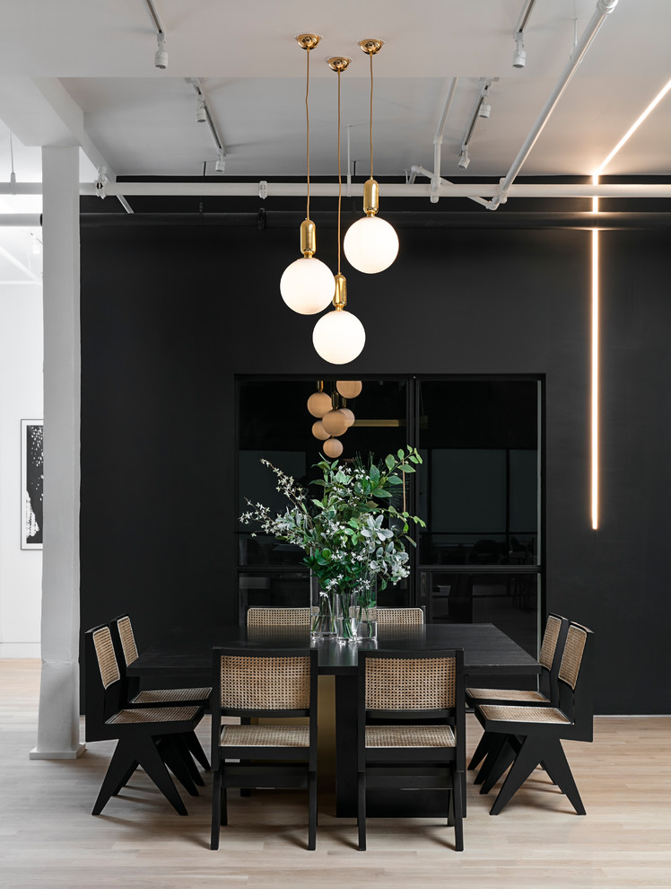 Design ideas for a large industrial dining room in New York with black walls, light hardwood floors, no fireplace and beige floor.